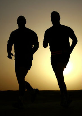 Two men running side by side 