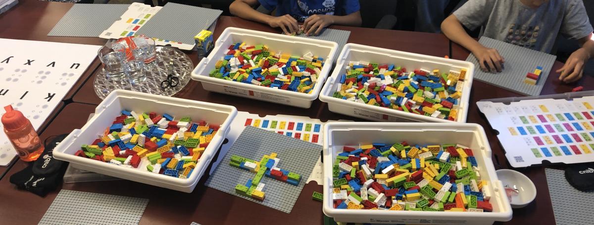 Des enfants jouent avec des blocs LEGO en braille