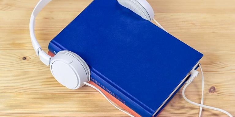 a blue book with headphones resting on top.