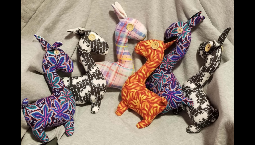 Six Llamas en peluche colorés. Les lamas ont des éléments tactiles, comme des yeux en forme de boutons. 