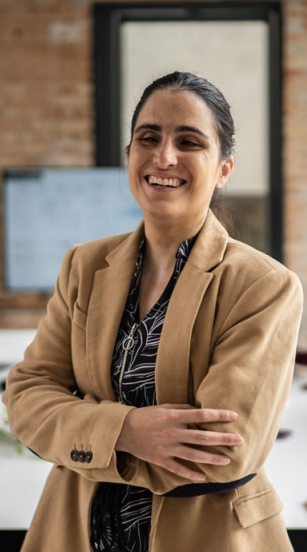 A woman smiles confidently into the camera