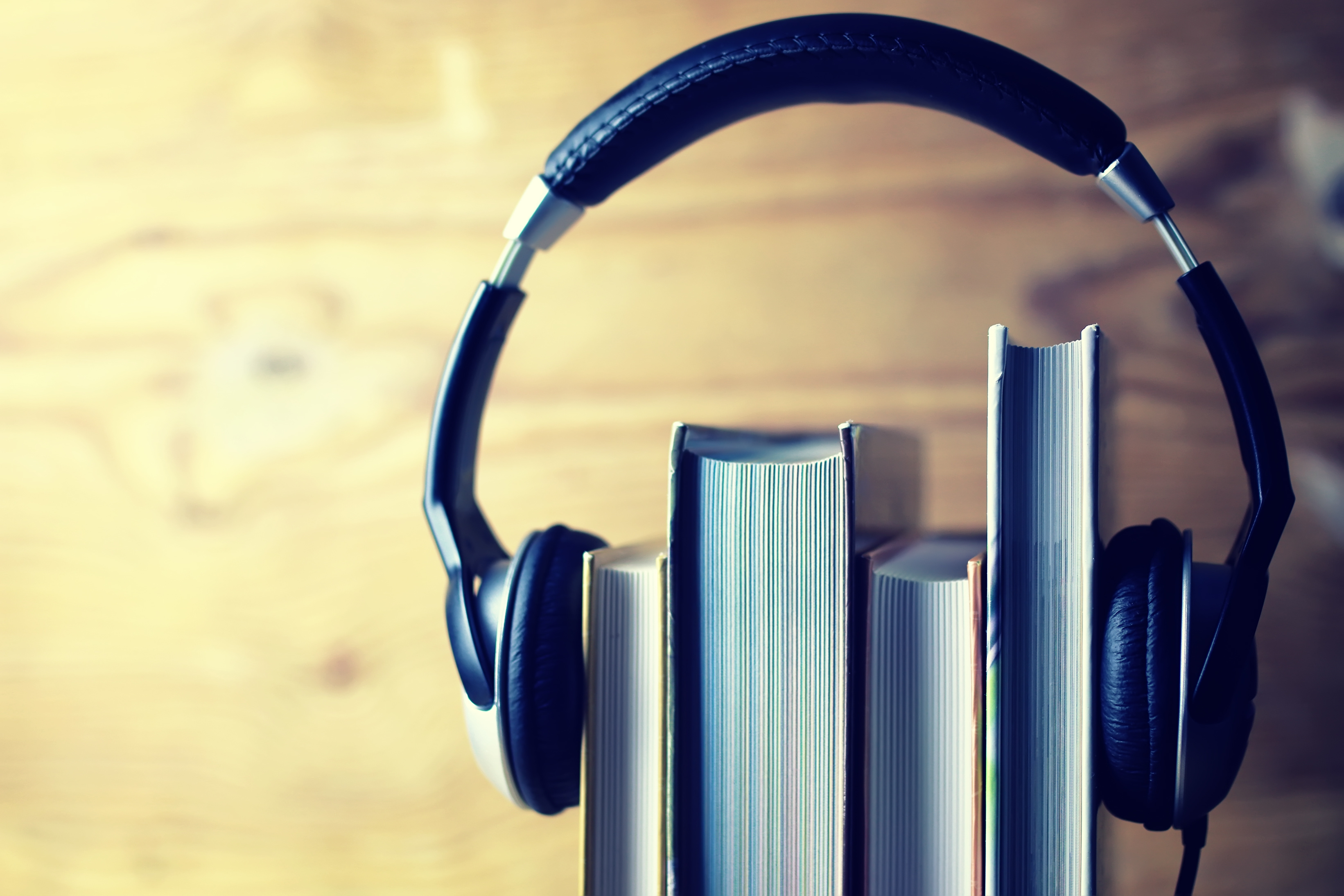 A photo of a set of headphones placed over four books.