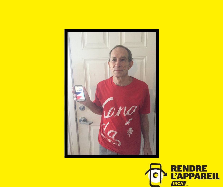 Bill Chadd pose pour une photo avec son téléphone intelligent. Il porte un tee-shirt rouge du Canada et se tient devant une porte en souriant et en tenant un iPhone dans la main droite.