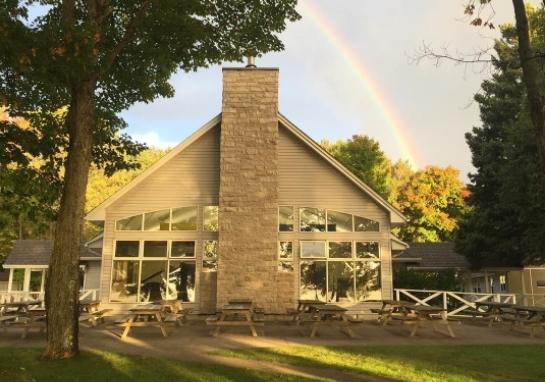 Outside photo of the Lounge with a rainbow in the background.
