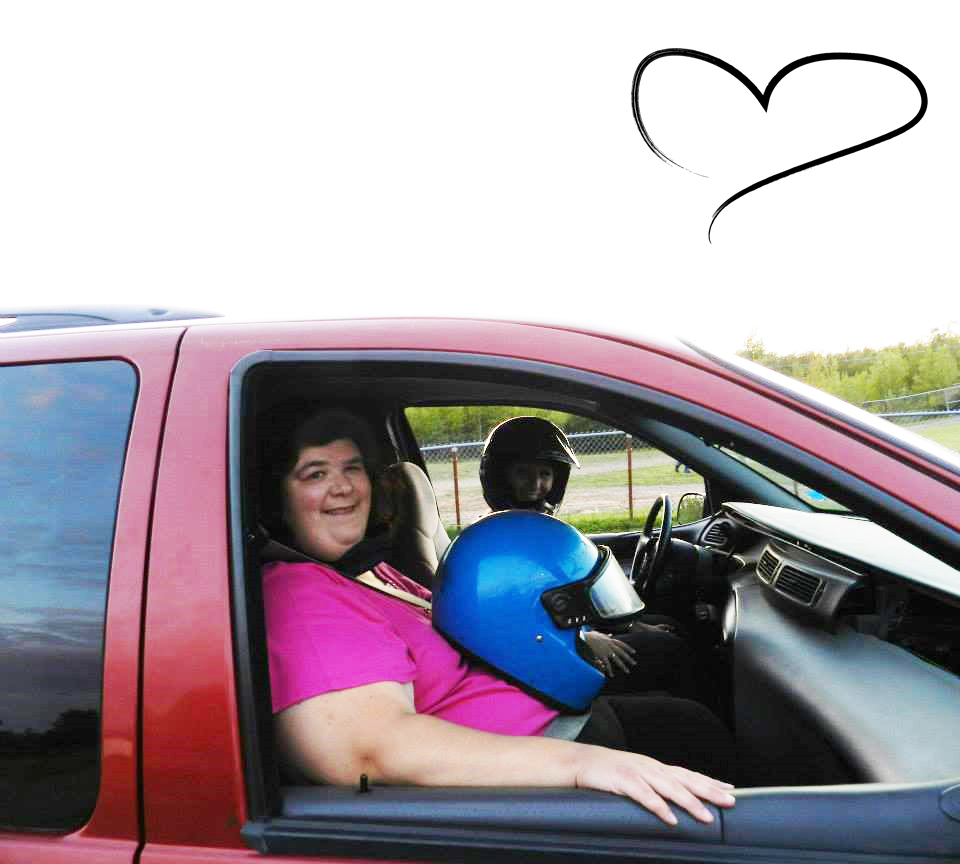 Julie Morneault assise dans un camion rouge avec un casque de moto bleu sur les genoux. Un dessin de cœur apparaît dans le ciel.
