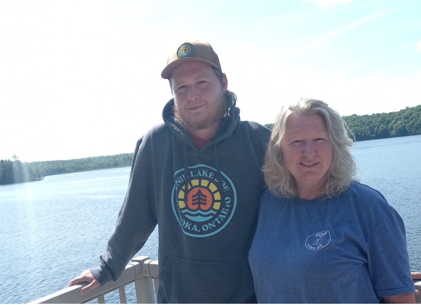 Kathy and her son Clayton stand on a waterfront balcony at their cottage.