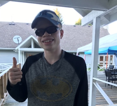 Munashe Nya gives the thumbs up on the deck near the Welcome Centre at CNIB Lake Joe.