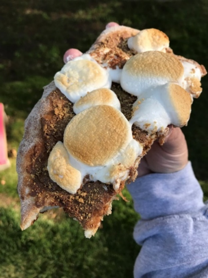 A s'mores pizza slice! Gooey marshmallows litter the top of the slab.