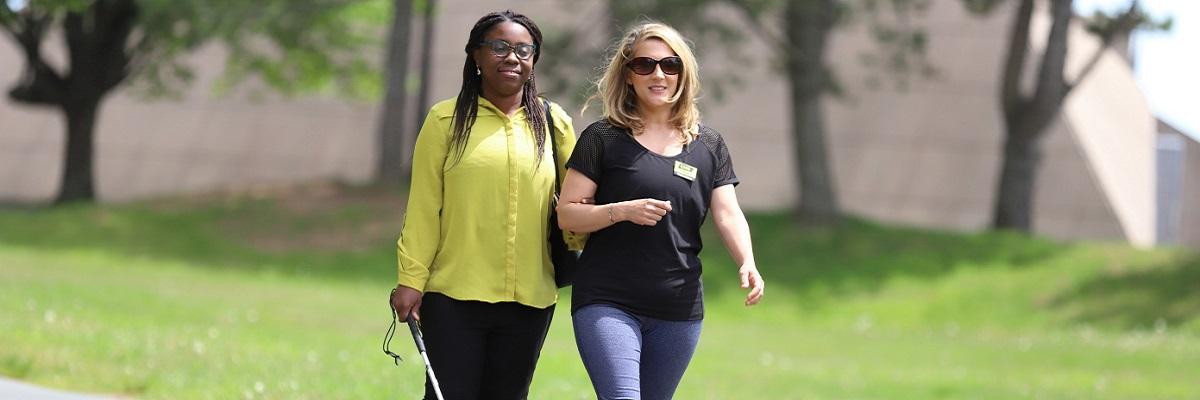 A CNIB volunteer and participant enjoying a walk in the sun