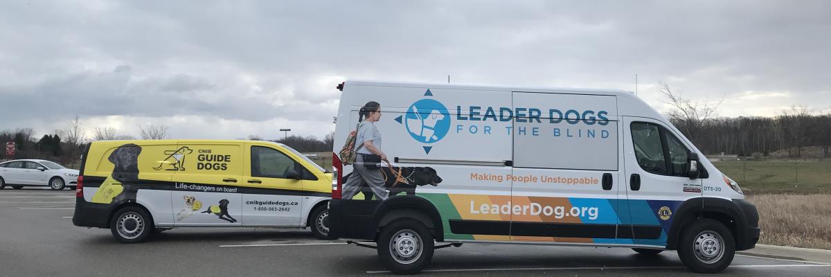 A CNIB Guide Dogs branded van (left) parked next to a Leader Dogs for the Blind van (right).