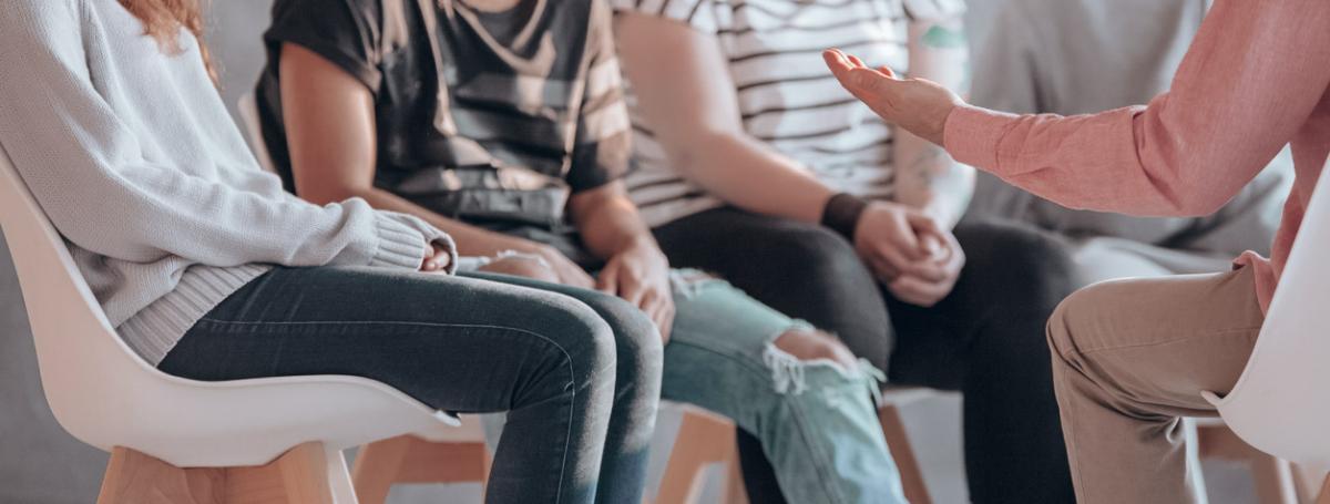 A group of five people sit in a circle and engage in lively conversation.