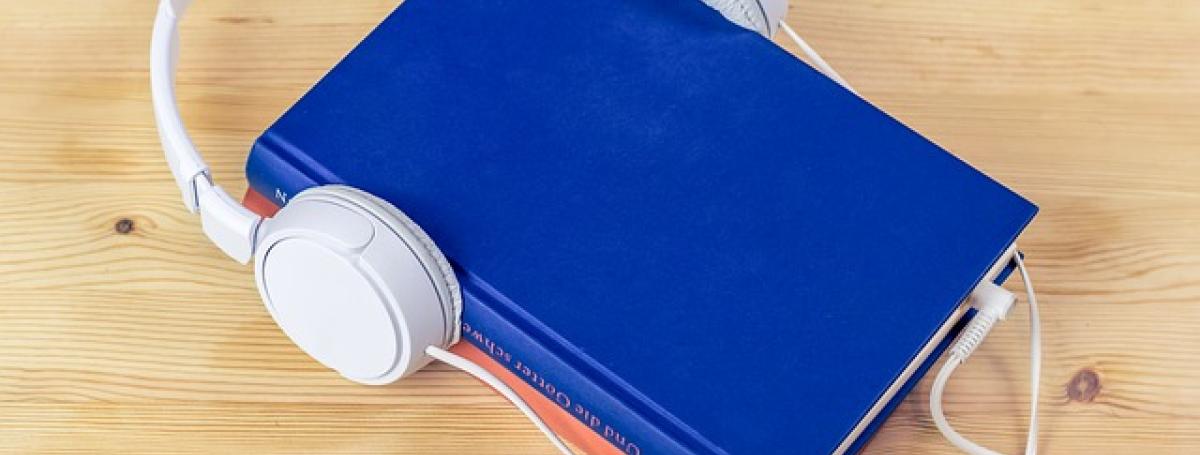 a blue book with headphones resting on top. 