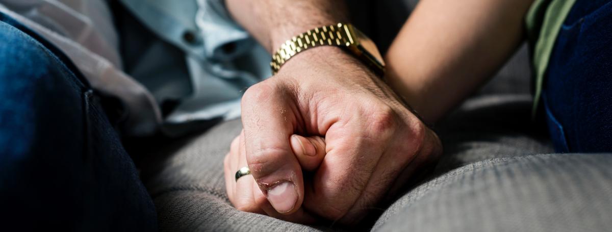 Close up of two peoples clasped hands.