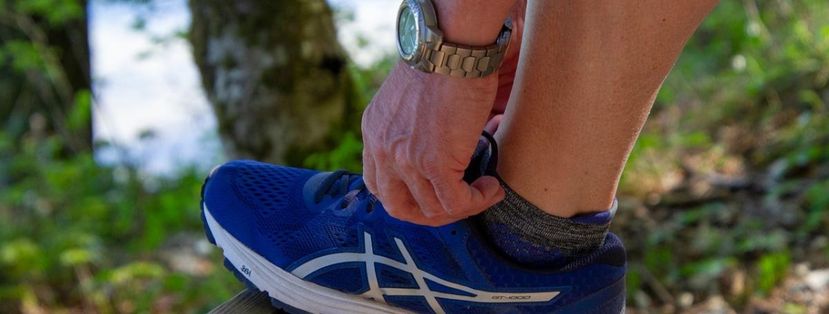 A person laces up a running shoe.