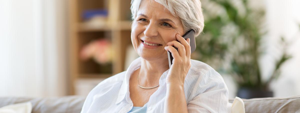 An elderly woman talks on a smartphone.