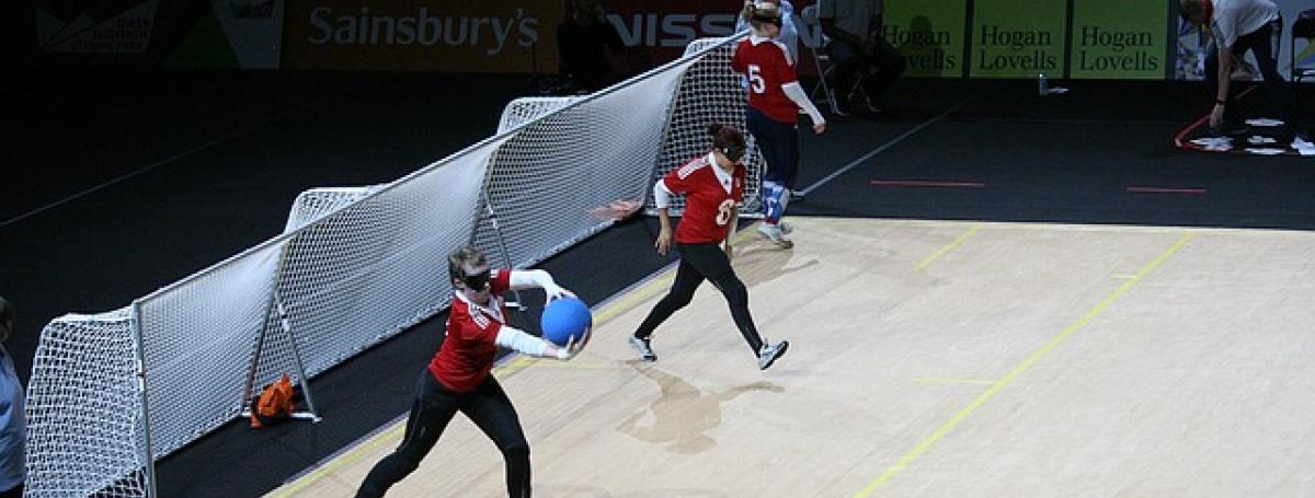 Three people practicing goalball guarding nets.