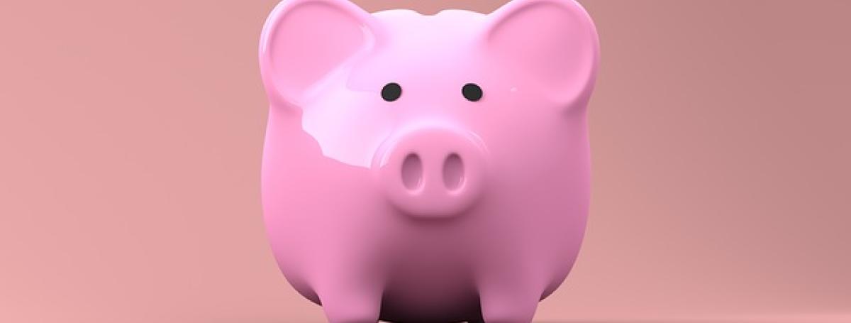 A pink piggy bank sits on a tabletop.