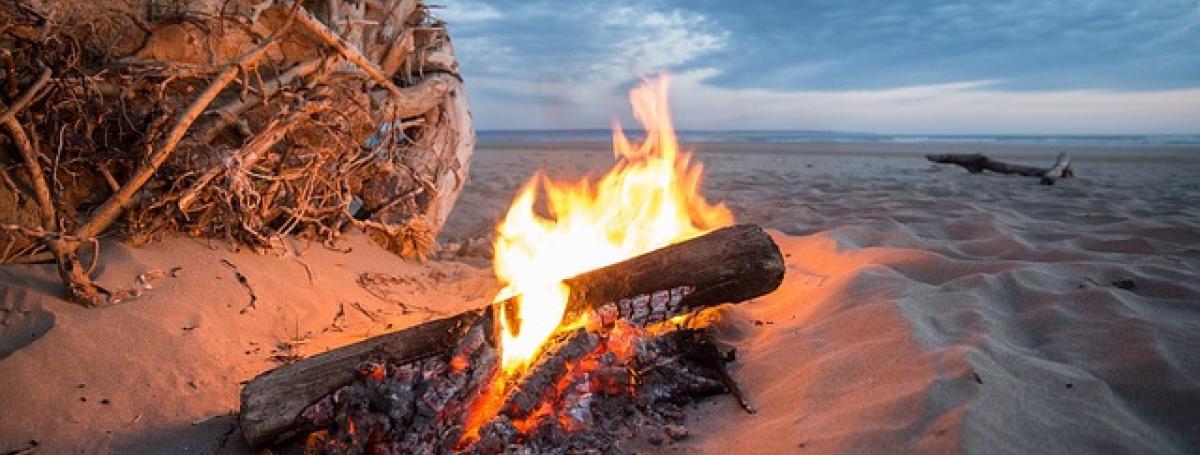 A campfire on a sandy beach. 