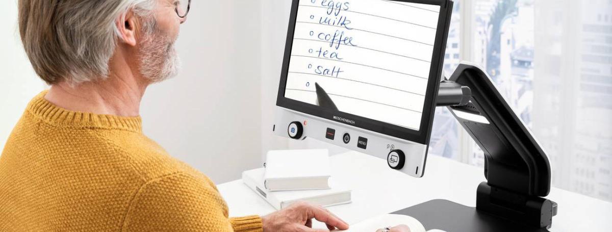 A man uses the Vario Digital FHD video magnifier.