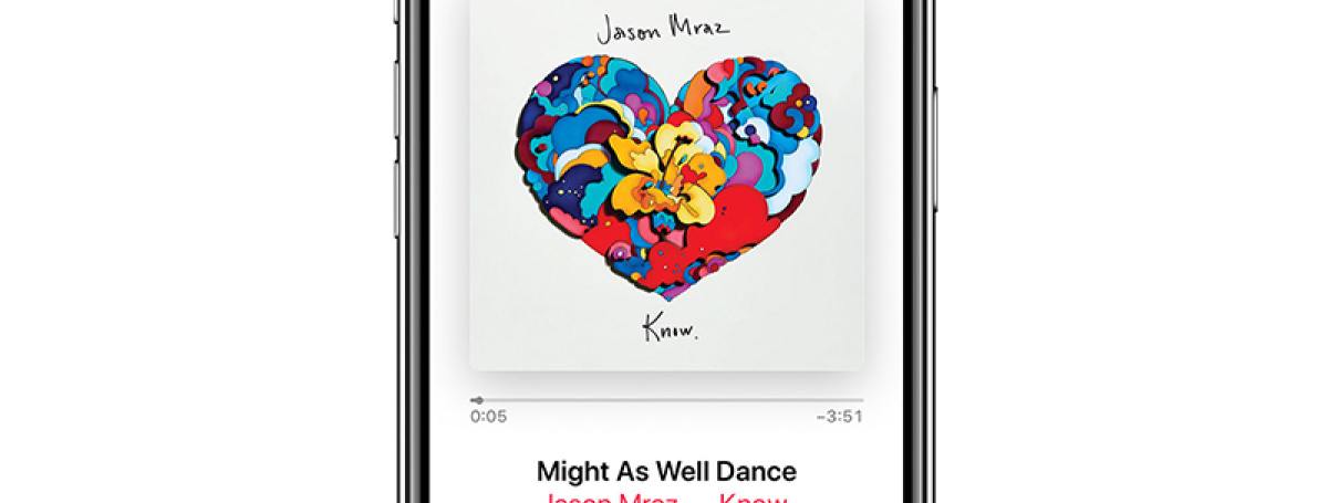 An iPhone displays the Apple Music app playing a Jason Mraz song.