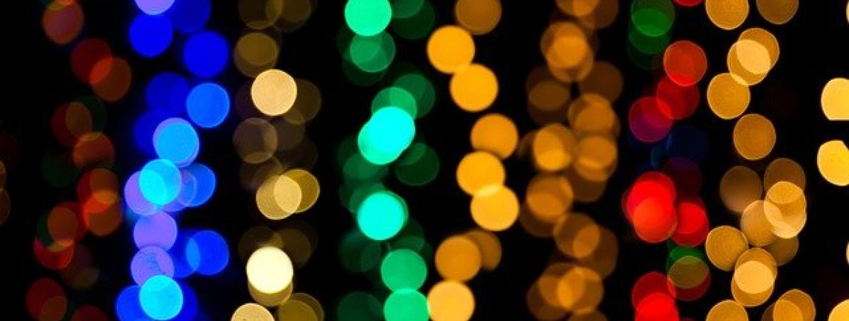 An abstract design of glittering rainbow-coloured christmas tree lights.