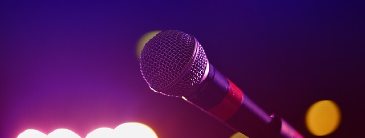 A microphone sits in a tripod stand.