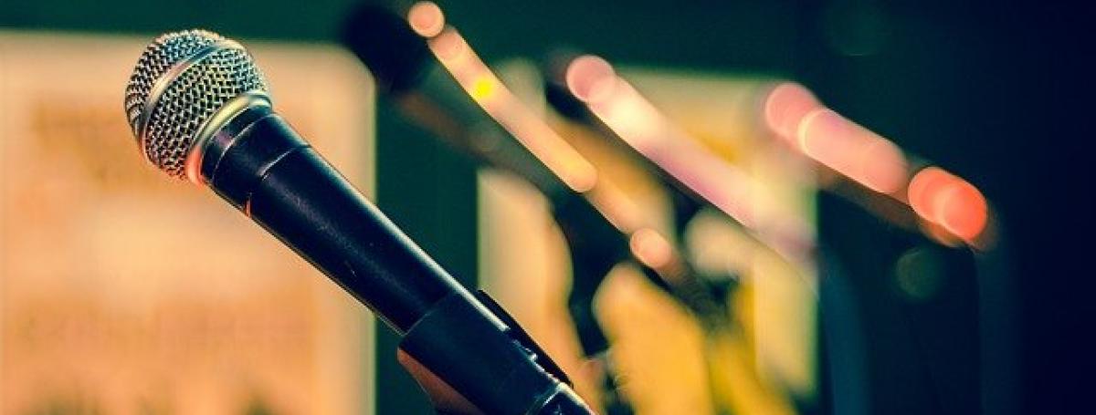 A microphone sits in a tripod stand.