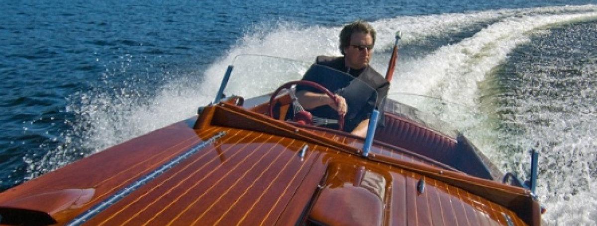 Man driving a wooden boat.