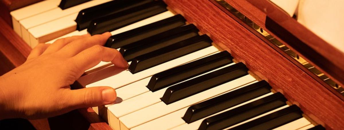 Left hand plays a piano keyboard.