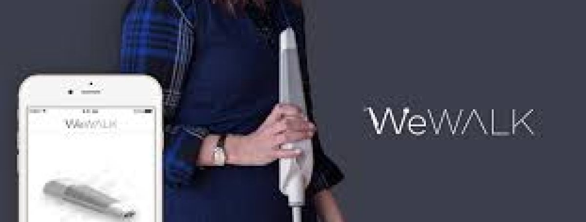 The WeWALK Smart cane in a woman's hand. To the left, an iPhone displays the WeWALK app.