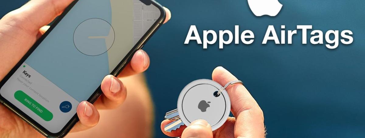 A hand holds a smartphone screen which displays the Apple AirTag app.