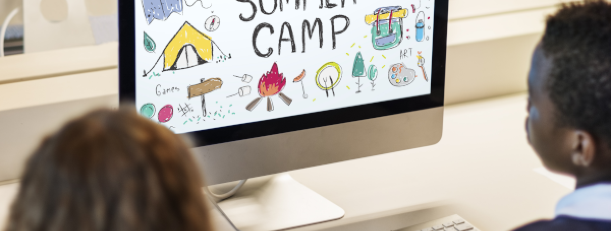 Two young children sit at a desktop computer. On the computer screen, an illustration appears. Text: Summer camp!