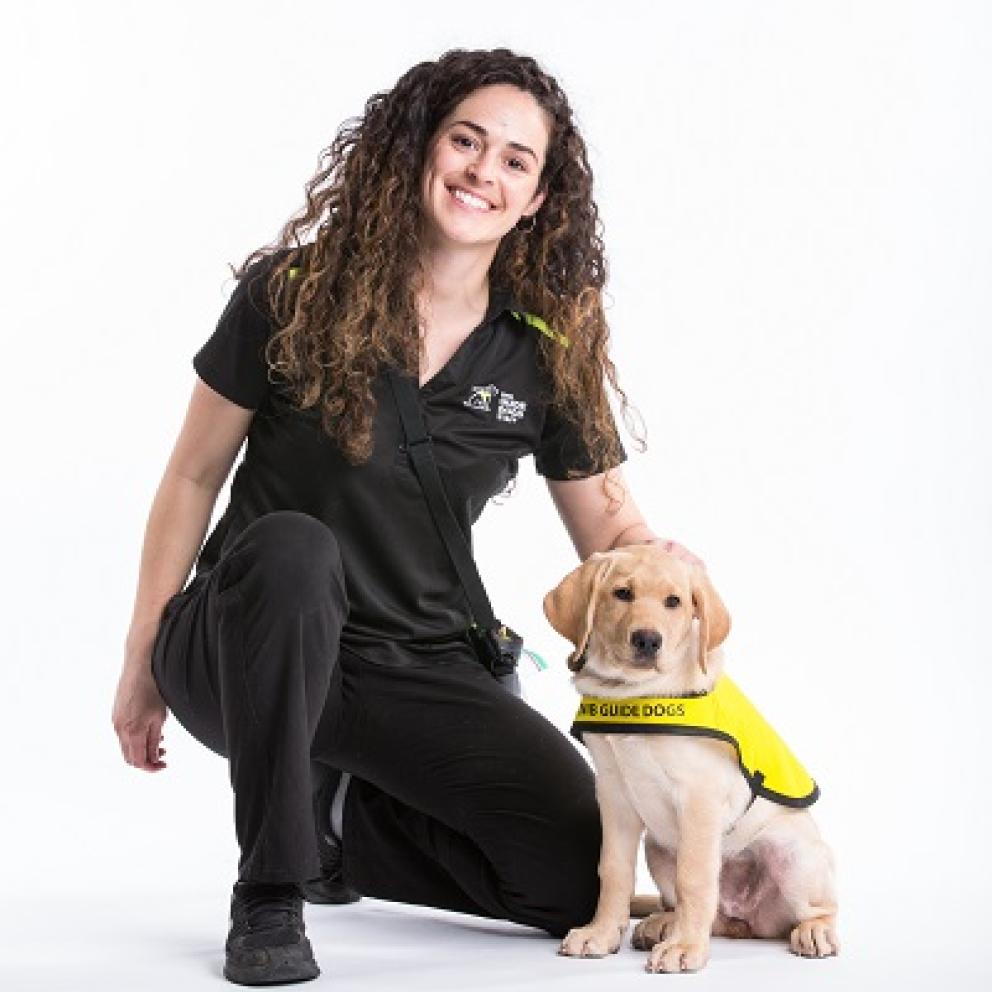 A CNIB Guide Dog puppy in training with her smiling handler