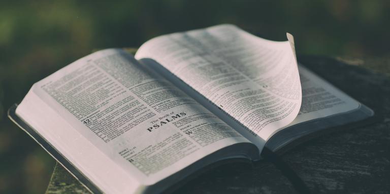 An open bible sits on a table.