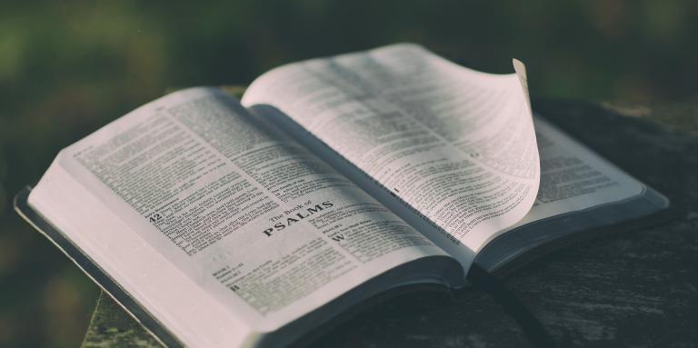 An open bible sits on a table. 