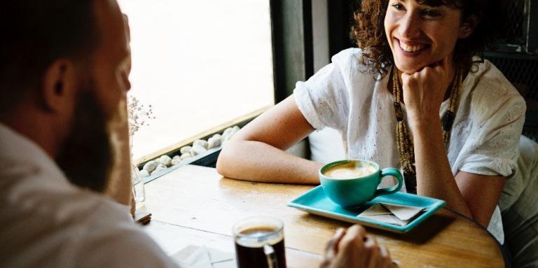 two people sitting at a table drinking coffee