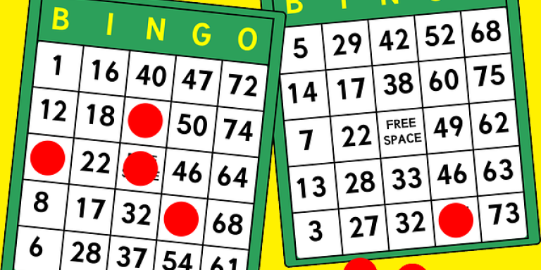 An illustration of two bingo cards and red, circular, chips marking the card.