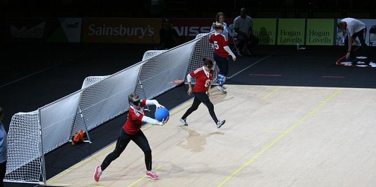 Three people practicing goalball guarding nets.