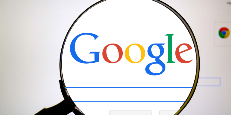 Page web de Google. Une loupe fait apparaître le logo de Google et la barre de recherche en plus gros.