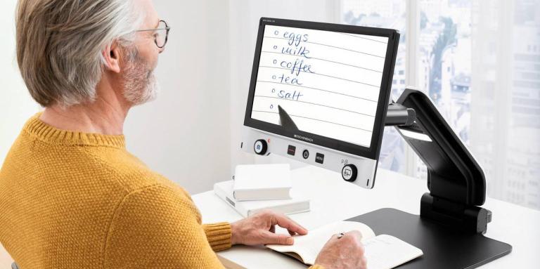 A man uses the Vario Digital FHD video magnifier.