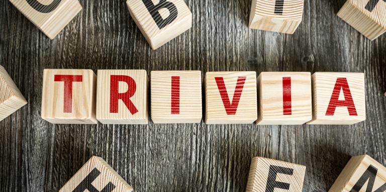 Wooden scrabble board keys spell out the word "Trivia"