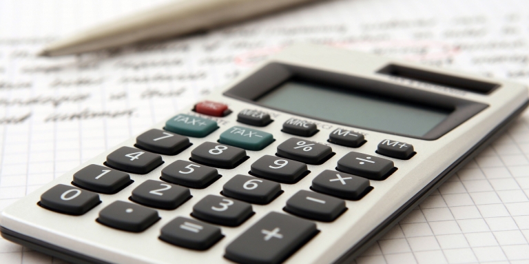 Plan rapproché d'une calculatrice déposée sur une feuille de calculs