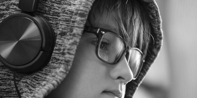 A young boy is wearing a big set of headphones.