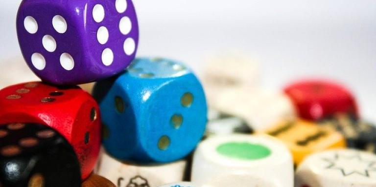 A pile of colourful dice and other game pieces.