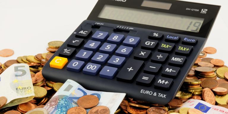 Une calculatrice sur un tas d'argent.