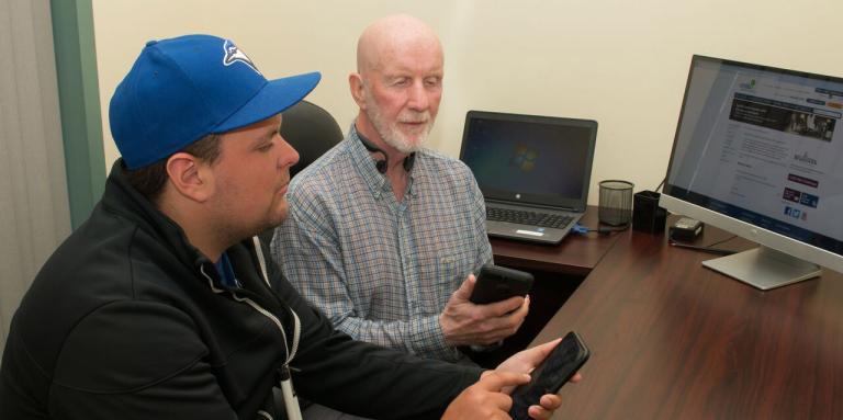 Two men using their mobile devices