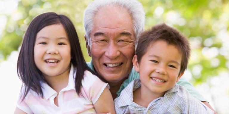 grand-papa souriant photographié avec ses petits-enfants