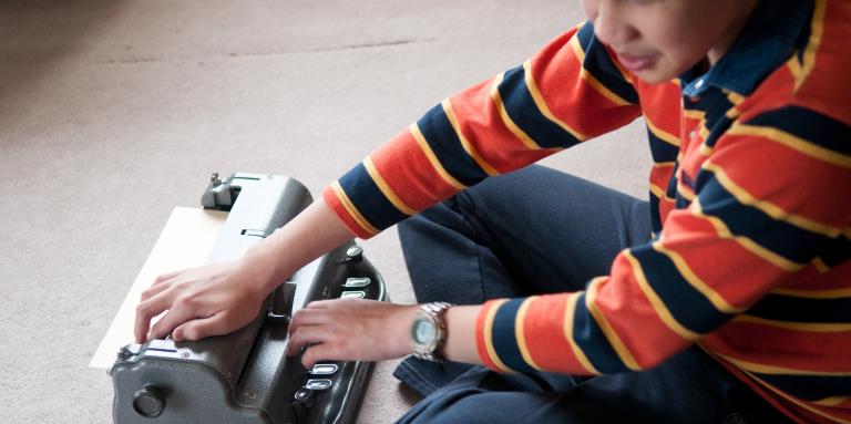Boy using a brailler