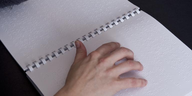 a hand reading braille