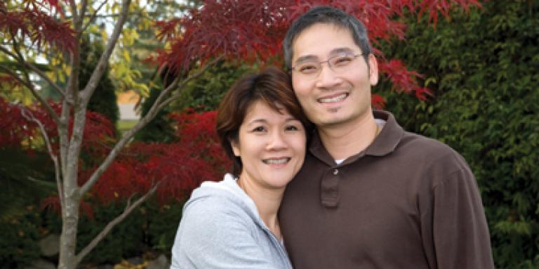 couple d’âge moyen souriant, à l’extérieur